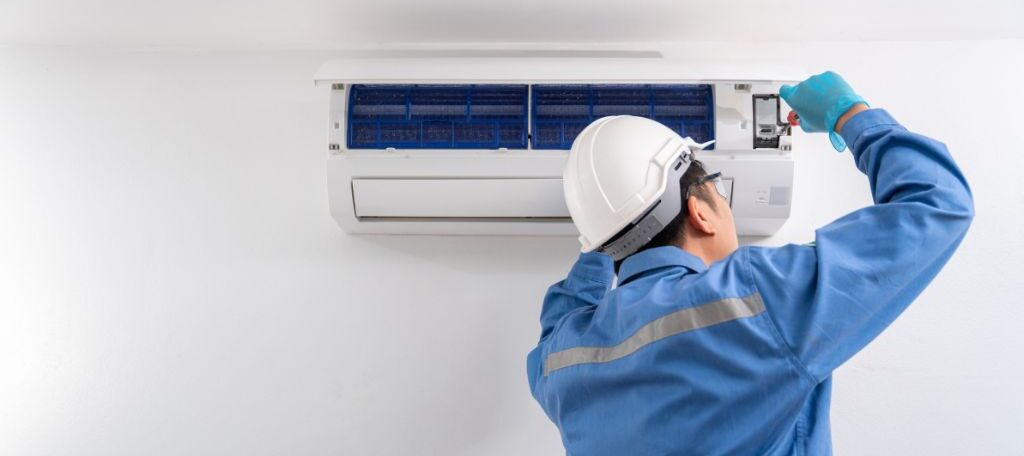 persona arreglando aire acondicionado